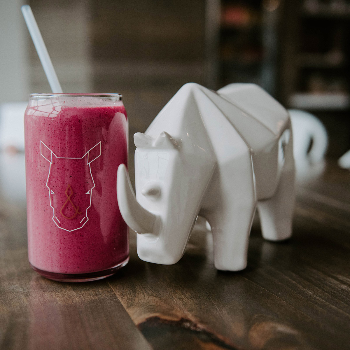 A statue of the Fix & Repeat rhino next to a glass of cold-pressed juice with the  Fix & Repeat logo